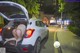 A woman is sitting in the trunk of a car.