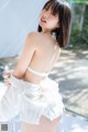 A woman in a white lingerie posing for the camera.