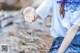 A little girl sitting on the ground with her hand outstretched.