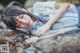 A woman laying on a rock in the water.