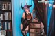 A woman in a black lingerie posing in front of a bookcase.