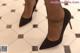 A close up of a woman's legs wearing black high heels.