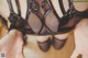 A close up of a woman's hands holding a black lingerie.