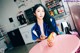 A woman sitting at a pink table eating a sandwich.