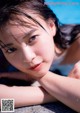 A young woman laying on the edge of a swimming pool.